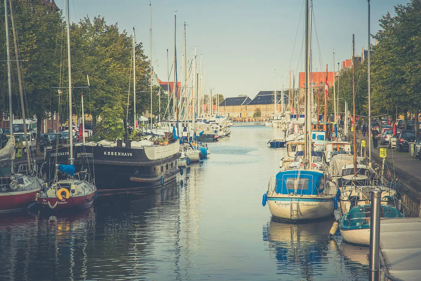 Sailboats moored along the Christianshavn canal in warm evening light
