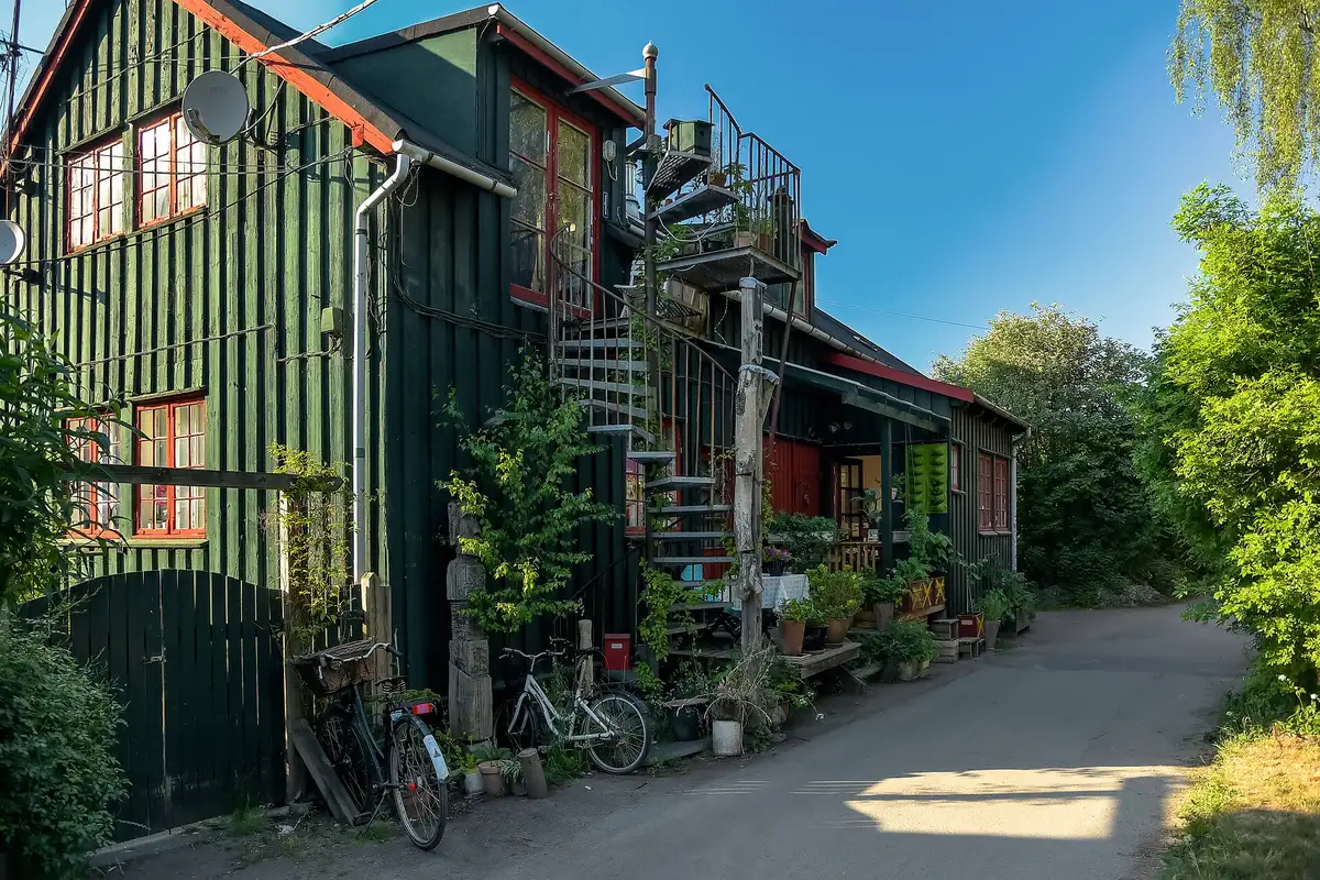 Self-built wooden houses and greenery along a lane in Christiania